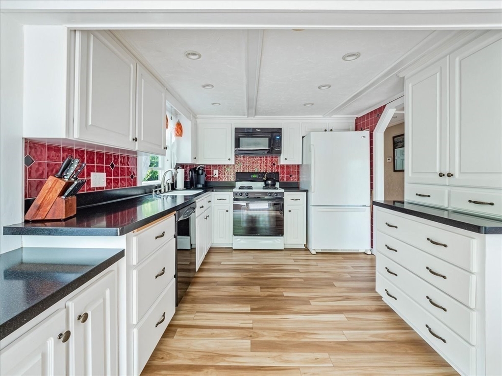 7 Ell Road Holbrook, MA 02343 - Photo 11 of 34 a kitchen with granite countertop a refrigerator and white cabinets