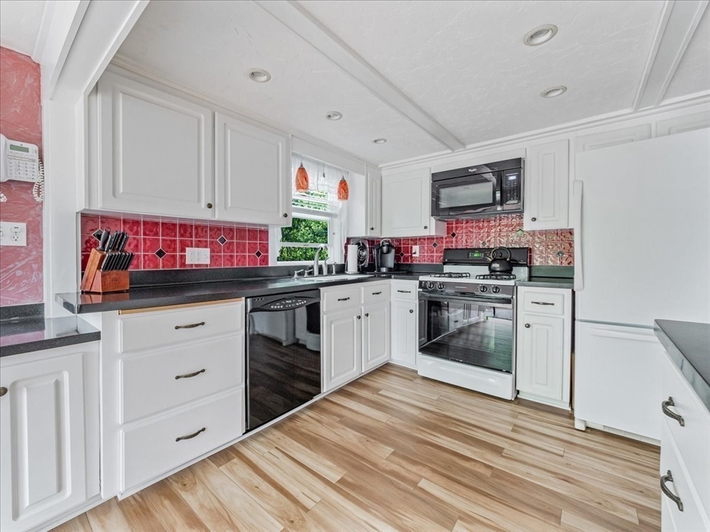 7 Ell Road Holbrook, MA 02343 - Photo 12 of 34 a kitchen with white cabinets and white appliances