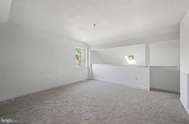 an empty room with windows and white walls