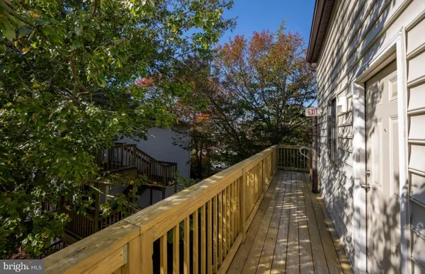 a balcony with wooden floor and trees in the back