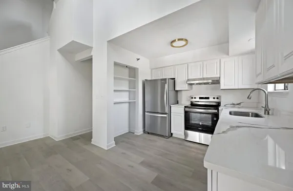 a kitchen with granite countertop a refrigerator and a stove top oven