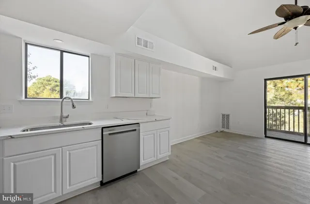 a kitchen with a sink cabinets appliances and a window