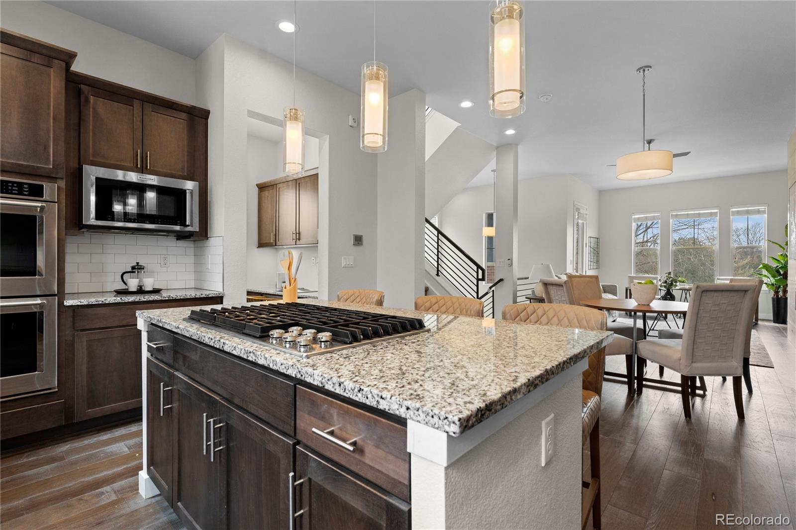 188 South Locust Street Denver, CO 80224 - Photo 9 of 29 a kitchen with a stove a sink a dining table and chairs with wooden floor