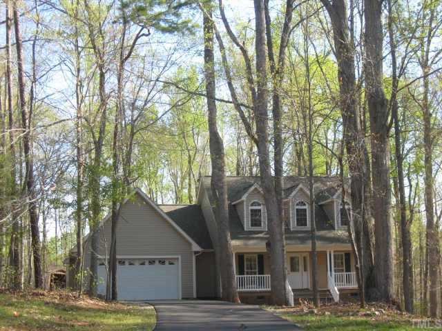a view of a big house with large windows and a tree