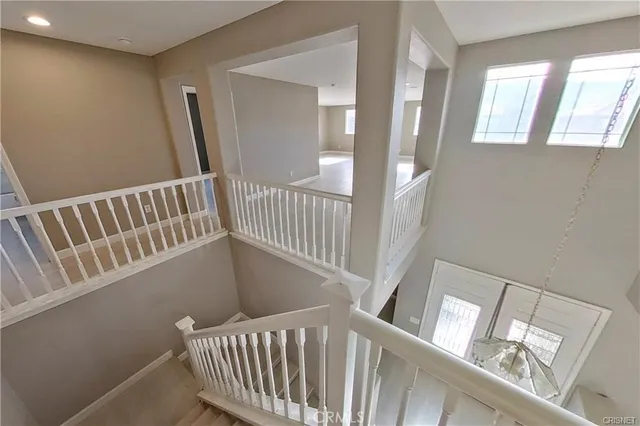 a view of staircase with railing and a rug
