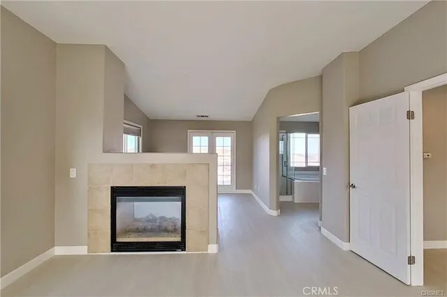 a view of an empty room with a fireplace and a window