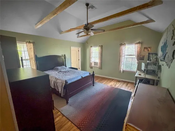 a living room with stainless steel appliances furniture a window and wooden floor