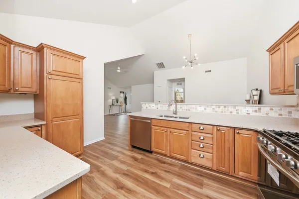 a large kitchen with stainless steel appliances granite countertop a sink stove and refrigerator