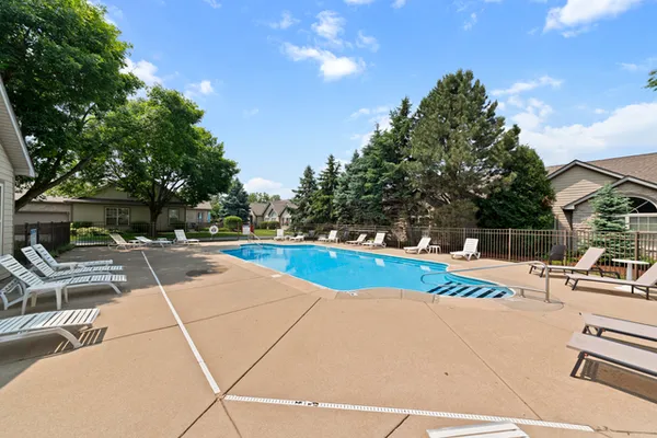 a view of a swimming pool with lawn chairs and couches
