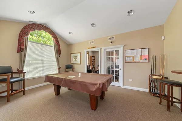 a room with pool table and windows
