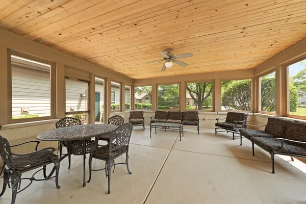 a dining room with furniture and large windows