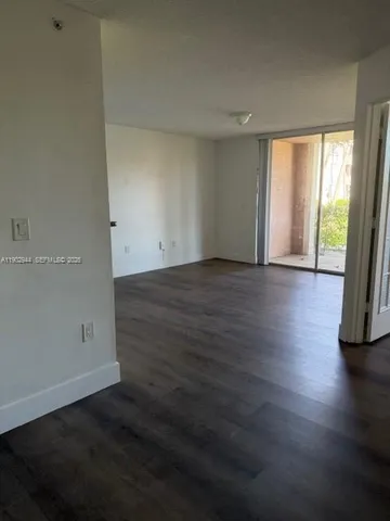 an empty room with wooden floor and door