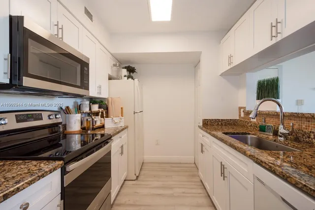 a kitchen with stainless steel appliances granite countertop a sink and a stove