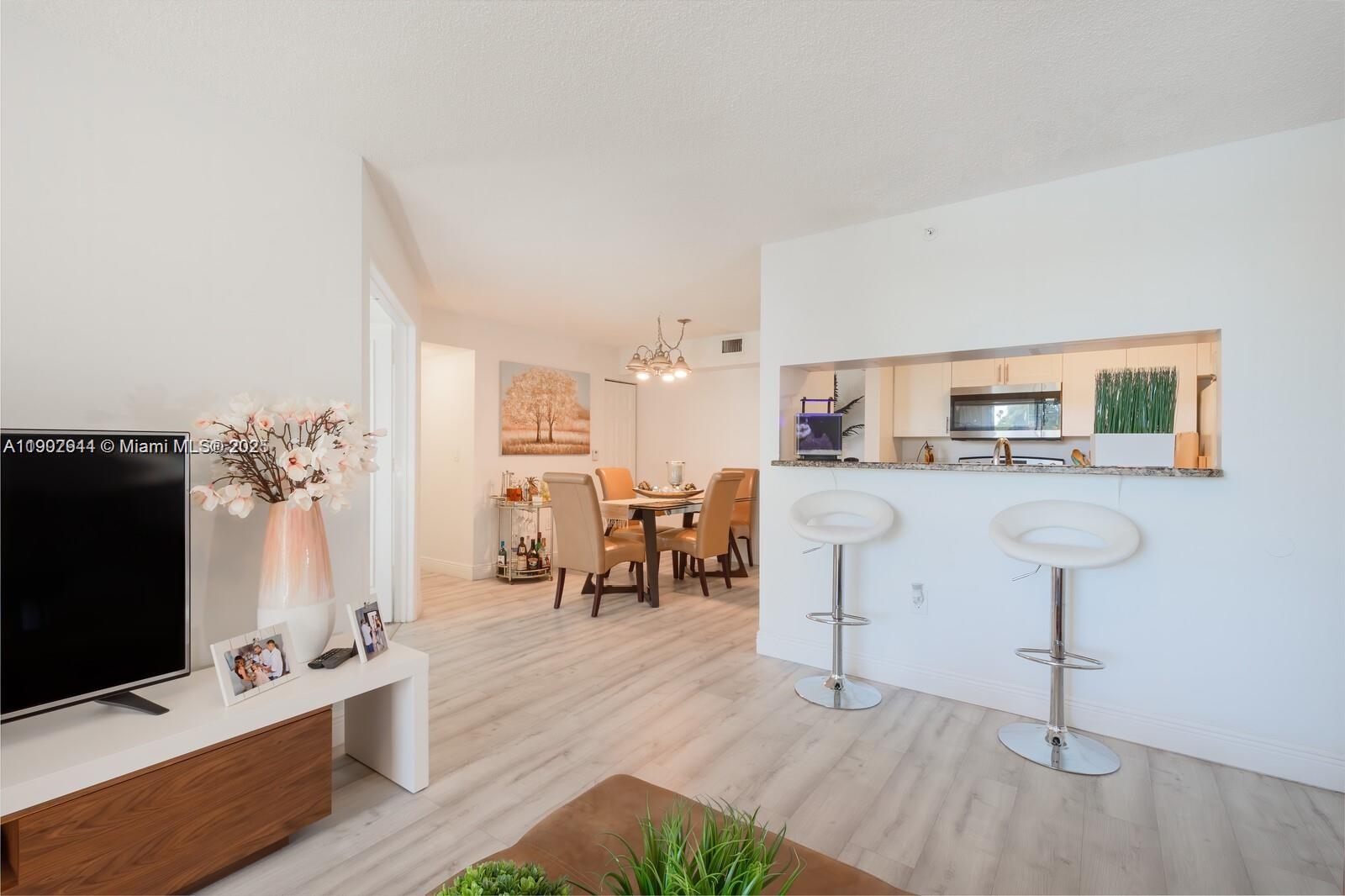 12160 St Andrews Place, Unit 108 Miramar, FL 33025 - Photo 5 of 16 a living room with furniture and a flat screen tv
