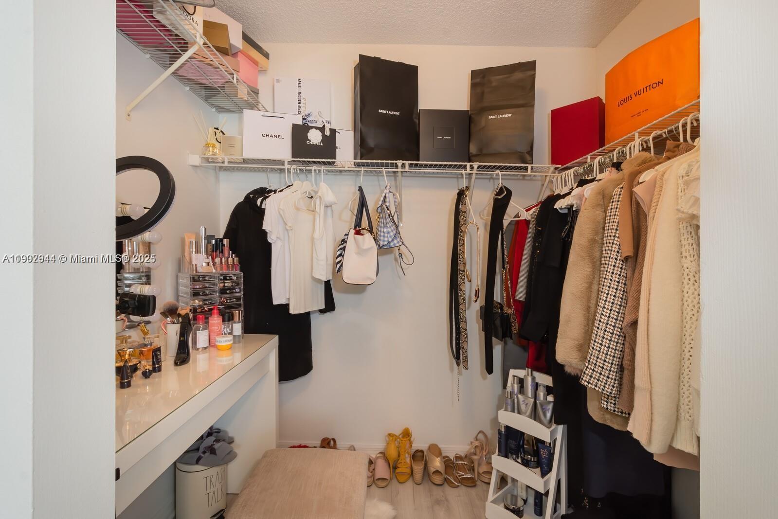 12160 St Andrews Place, Unit 108 Miramar, FL 33025 - Photo 8 of 16 a view of walk in closet with clothes and shoes