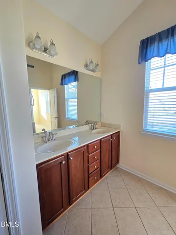a spacious bathroom with a granite countertop sink and a mirror