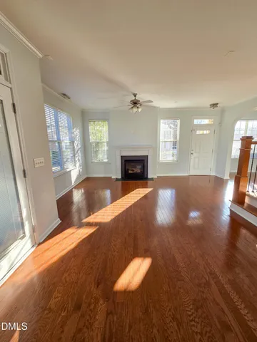a view of a livingroom with furniture a fireplace and wooden floor