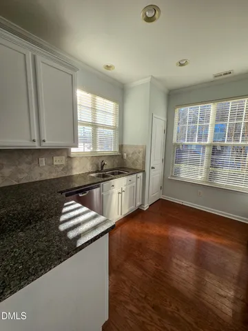 a kitchen with granite countertop a sink and a stove top oven
