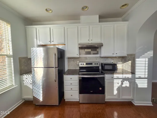 a kitchen with a refrigerator sink and cabinets