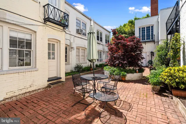 a front view of a house with a yard and potted plants