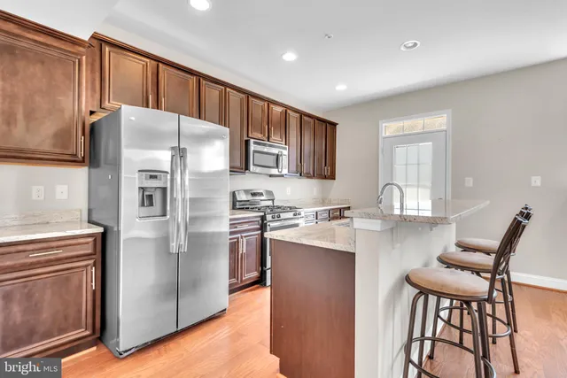a kitchen with stainless steel appliances granite countertop a refrigerator stove microwave and sink