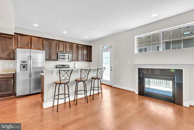 a kitchen with stainless steel appliances a refrigerator a stove top oven and a center island