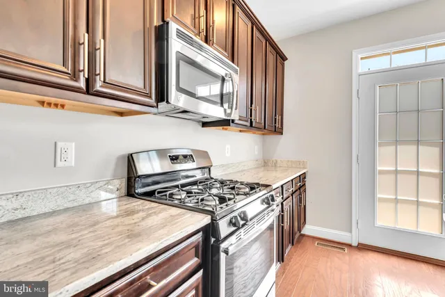 a kitchen with stainless steel appliances granite countertop a stove and a microwave