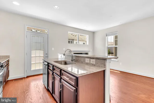 a kitchen with stainless steel appliances granite countertop a sink stove and wooden floor
