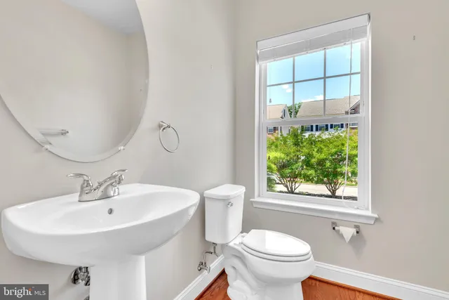 a bathroom with a sink a toilet and a window