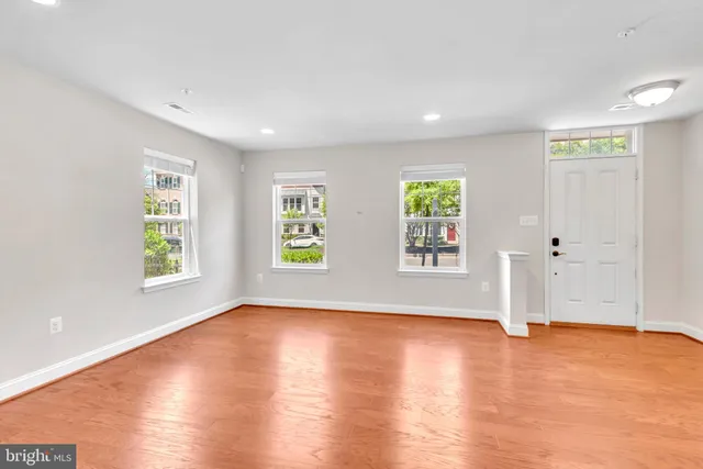 an empty room with wooden floor and window