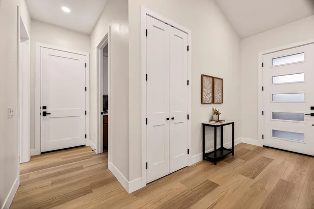a kitchen with stainless steel appliances kitchen island granite countertop a table chairs and a wooden floor