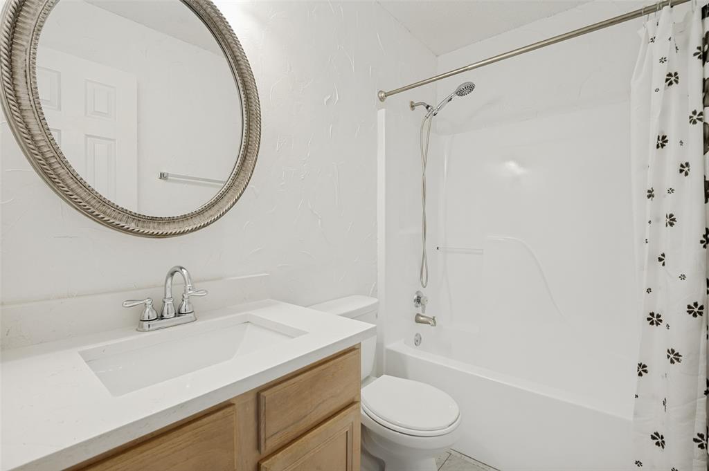 8160 Tower Road Frisco, TX 75035 - Photo 21 of 25 a bathroom with a sink a toilet and a mirror