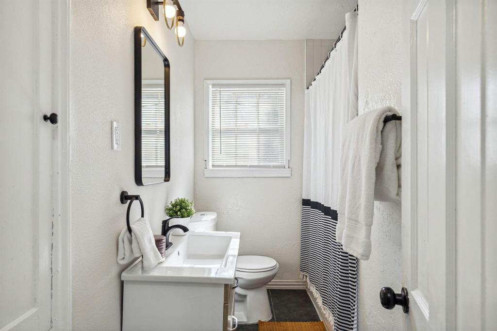 2435 West 10th Street Dallas, TX 75211 - Photo 16 of 38 a bathroom with a sink toilet and shower