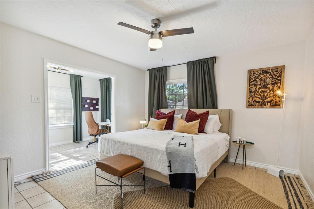 2435 West 10th Street Dallas, TX 75211 - Photo 21 of 38 a bedroom with a bed and a chandelier