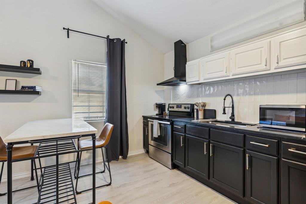 2435 West 10th Street Dallas, TX 75211 - Photo 27 of 38 a kitchen with stainless steel appliances granite countertop a sink stove and refrigerator