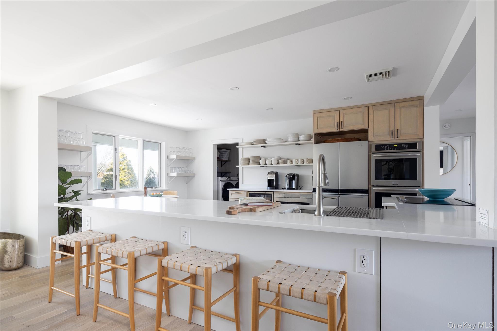 56861 Private Rd B (main) Southold, NY 11971 - Photo 11 of 35 a kitchen with stainless steel appliances a stove top oven a sink a refrigerator white cabinets and chairs