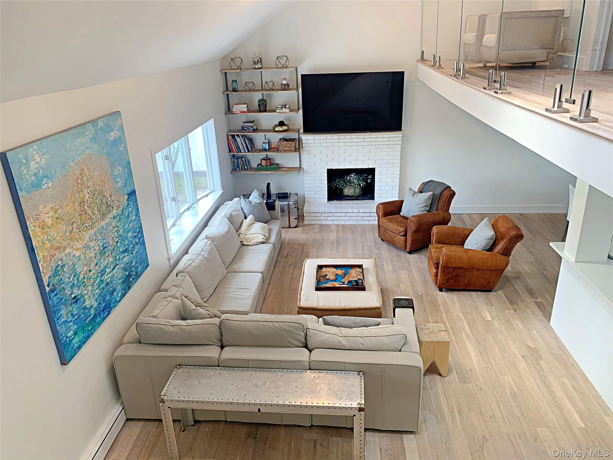 56861 Private Rd B (main) Southold, NY 11971 - Photo 17 of 35 a living room with furniture a flat screen tv and a fireplace
