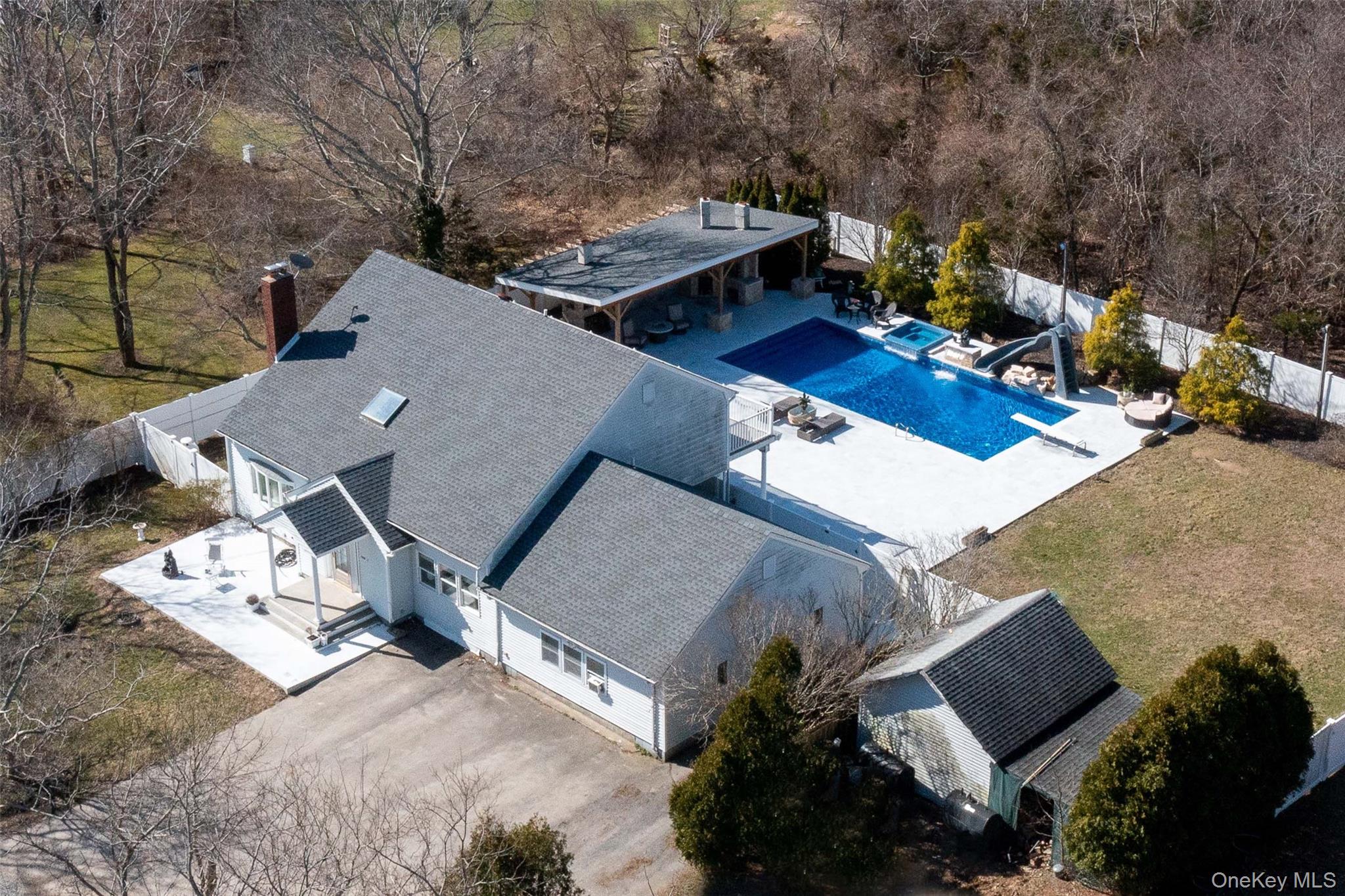 56861 Private Rd B (main) Southold, NY 11971 - Photo 30 of 34 Aerial view of property and surrounding area featuring a pool area and a tree filled landscape
