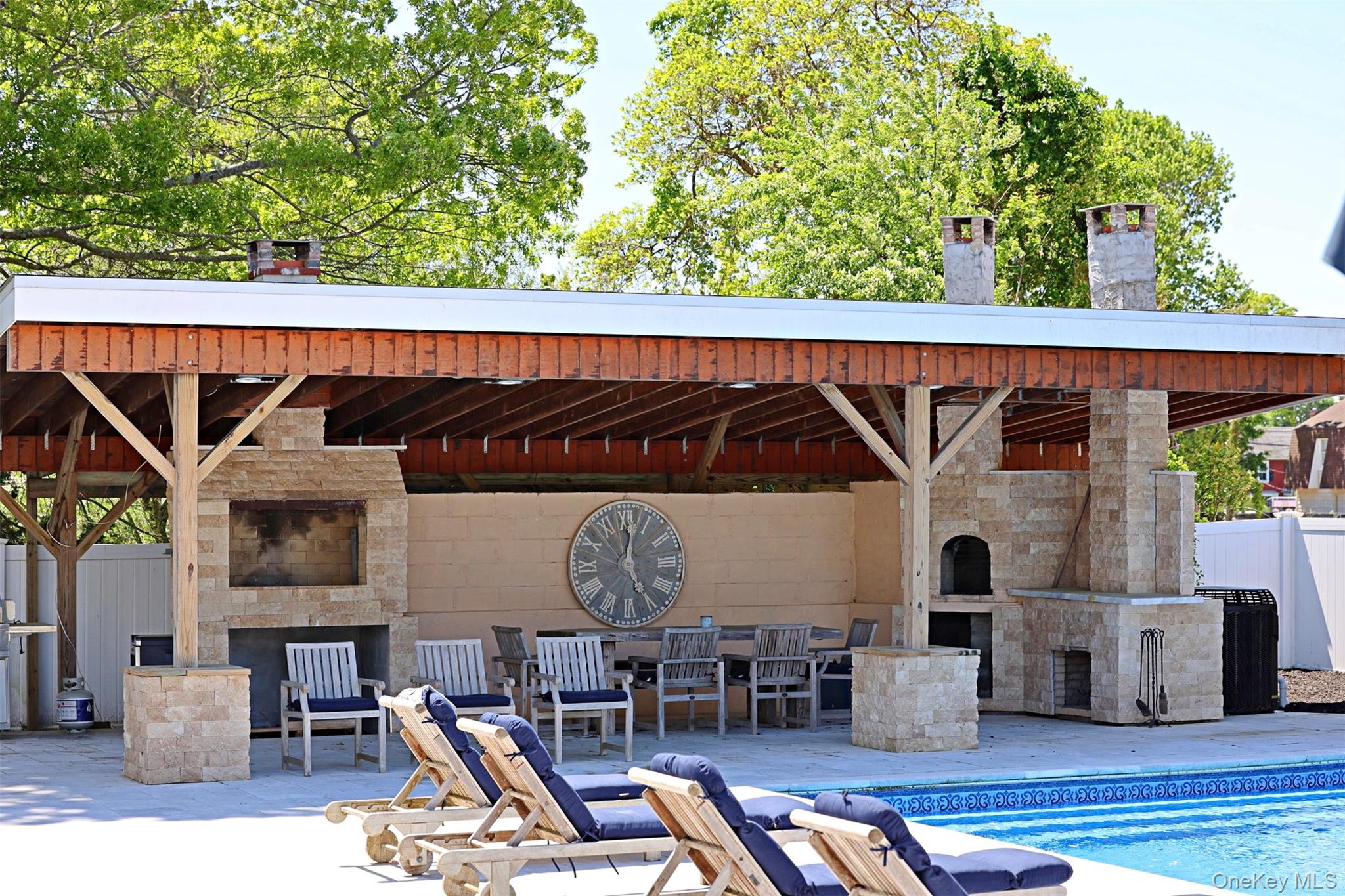 56861 Private Rd B (main) Southold, NY 11971 - Photo 5 of 34 View of patio / terrace featuring an outdoor stone fireplace and an outdoor pool