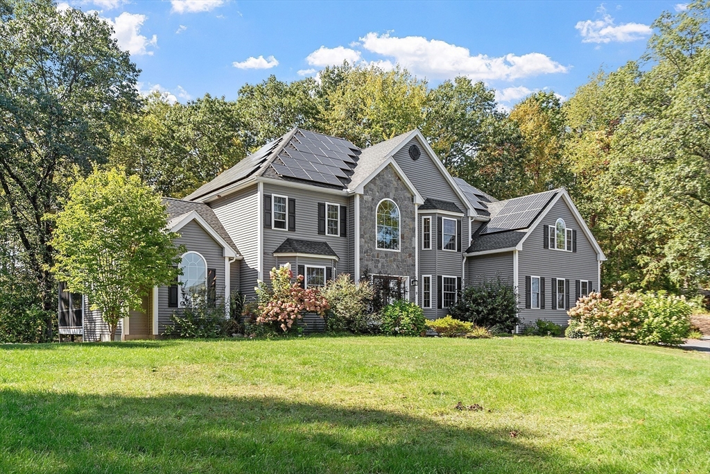 a front view of a house with a garden and plants