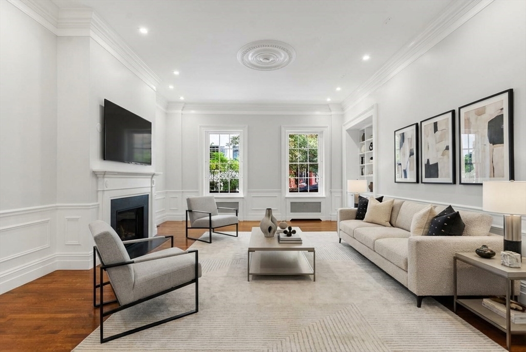 a living room with furniture a fireplace and a flat screen tv