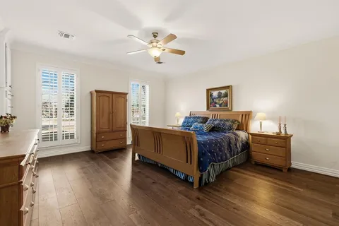 a spacious bedroom with a bed and wooden floor