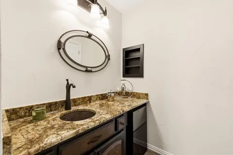 a bathroom with a granite countertop sink and a mirror