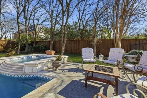 a view of a backyard with sitting area furniture and trees