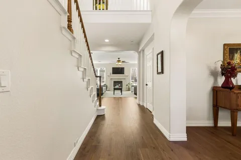 a view of a hallway with wooden floor and staircase