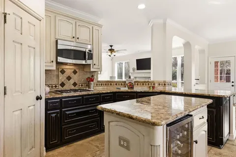a kitchen with granite countertop a sink stove and cabinets