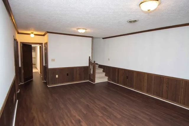 a view of a hallway with wooden floor and staircase