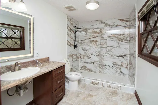 a bathroom with a sink toilet and shower