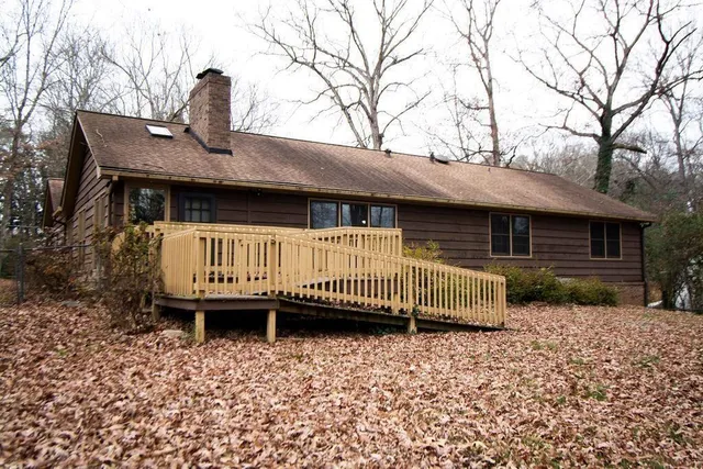 a backyard of a house with a bench and wooden fence