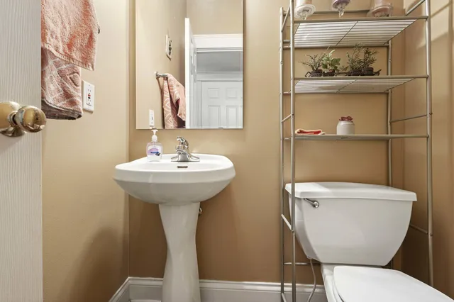 a bathroom with a toilet sink and mirror